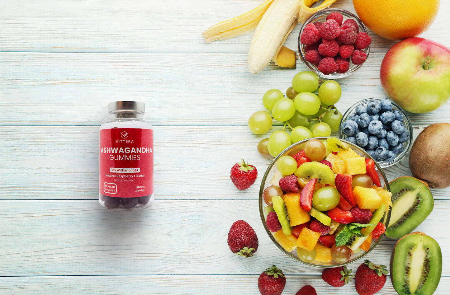 Vittera Ashwagandha gummies bottle surrounded by fruits on a light wooden surface